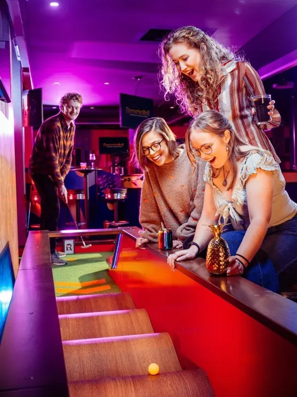 Des amies encouragent un putt sur le trou en pente
